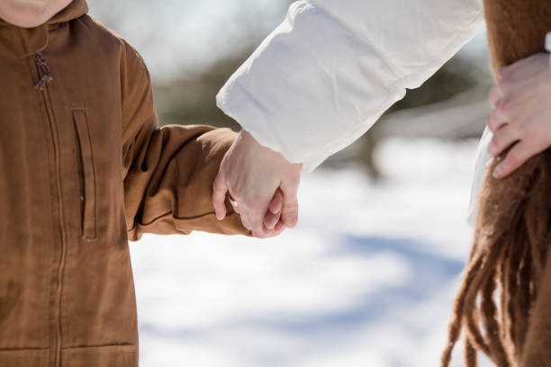 Couple in love walking and having fun outdoors in snow on sunny winter day