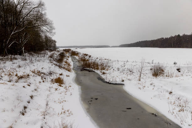 spots from falling snowflakes are visible on the river and sky