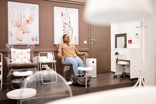 Black woman doing her pedicure in a beauty salon