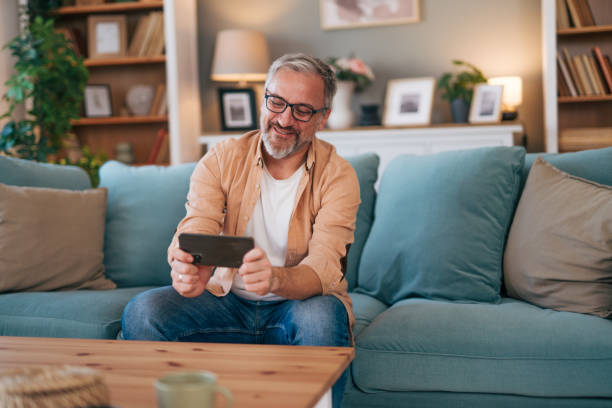 istock Middle age man relaxing at home using phone 2027658623