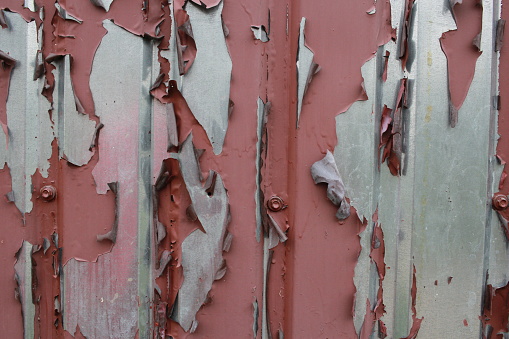 Photo the peeling paint of a painted brown corrugated board fence. Painting.