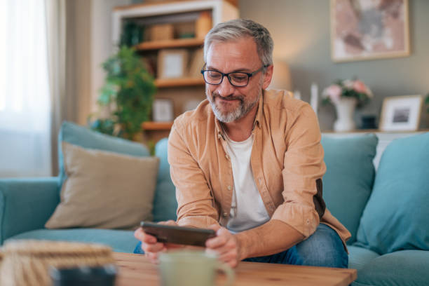 istock Smiling man watching video at his phone 2027681923