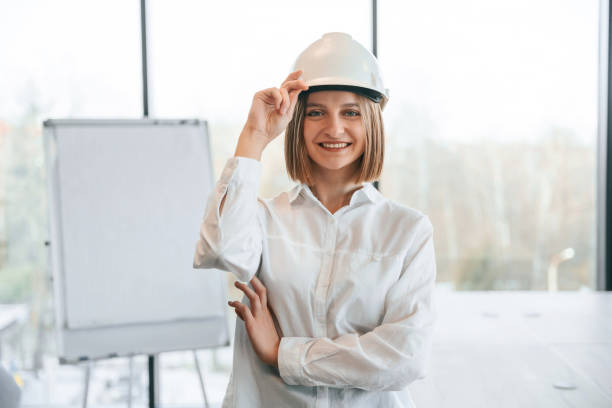 istock Young woman architect in hard hat is in office 2027738711