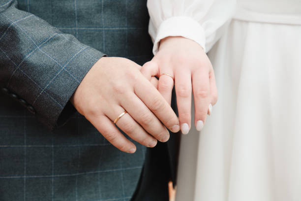 istock Bride and groom holding hands, close-up 2027743456