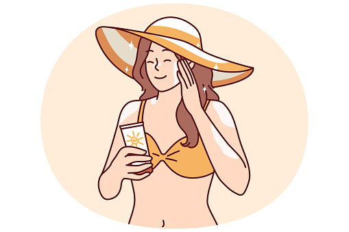 Woman who wants to sunbathe applies sunblock cream to skin to protect herself from sunstroke or to avoid excessive tanning. Girl in bikini and beach hat uses sunblock cream enjoy summer vacation