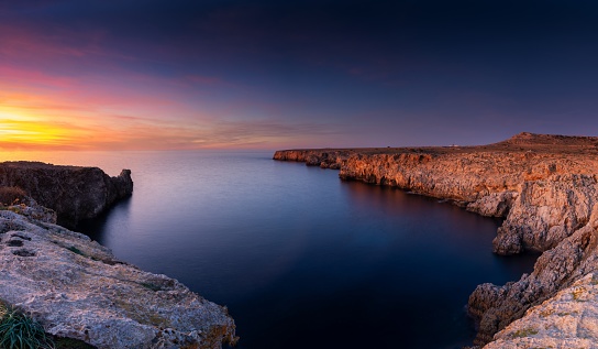 Landscape view of cliffs and rugged shorelina at Pont d'en Gil in northeastern Menorca near Ciutadella at sunset