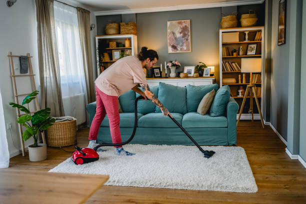 istock Man cleaning house with vacuum cleaner 2027781213