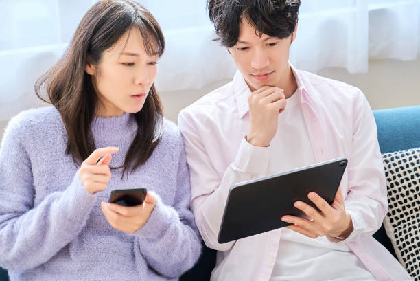 istock A man and a woman comparing smartphone and tablet PC screen 2027782256