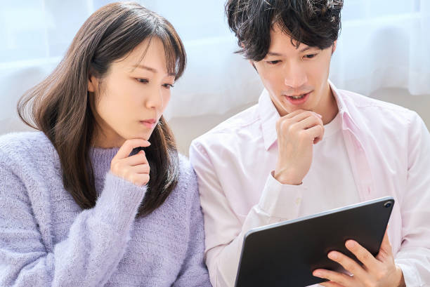 A man and a woman comparing smartphone and tablet PC screen