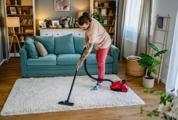 istock Man cleaning a carpet with a vacuum cleaner 2027789133