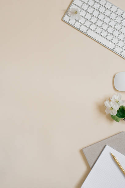 istock Workspace with a computer, white flowers and stationery on a pastel beige background. Distance work, online learning concept with place for text. 2027810723