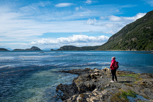 Tourist standing in front of the immense Beagle Channel in Patagonia, Argentina. Happy tourist touring Argentine Patagonia. Woman touring southern Argentina