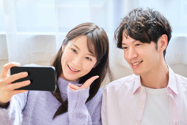 istock Young man and woman looking at smartphone screen 2027815646