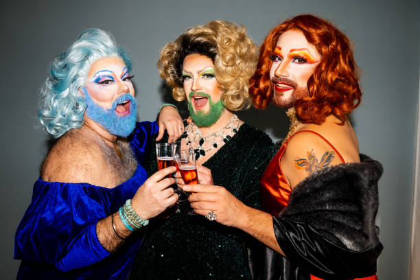 istock Three glamorous drag queens toasting with champagne at a festive gathering 2027818330