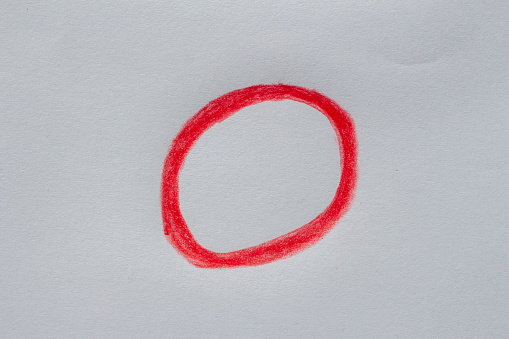 Hand drawn red circle on white paper. Copy space, clipping path.