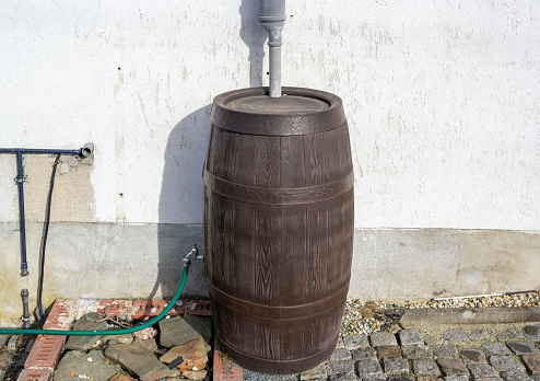old wooden barrel for rainwater in the garden