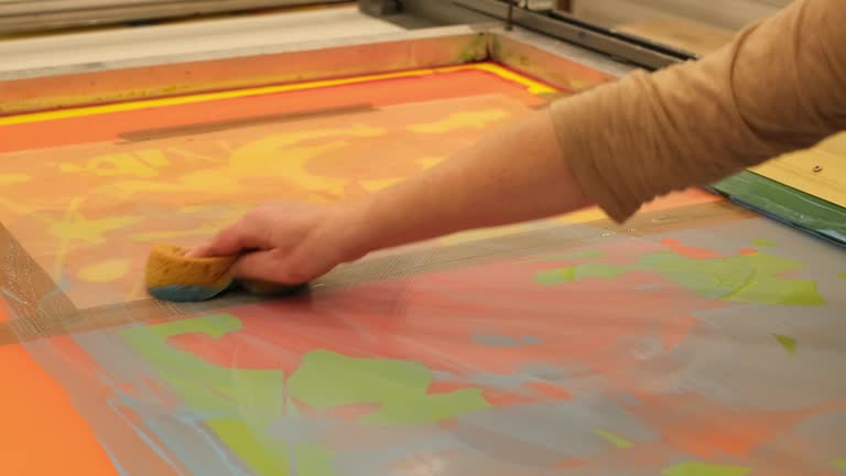 Woman cleaning the silk screen of a printing screen workshop