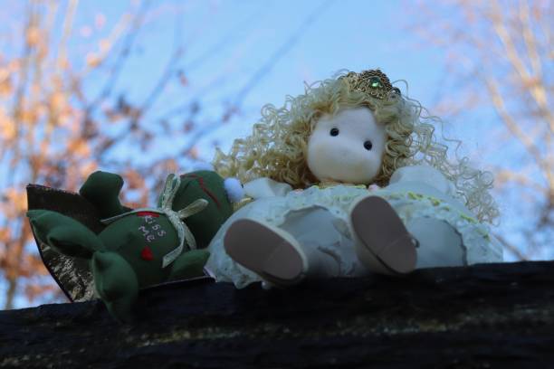 Photo of a small pair of porcelain dolls. Brother and sister. They are hugging and looking at the viewer.