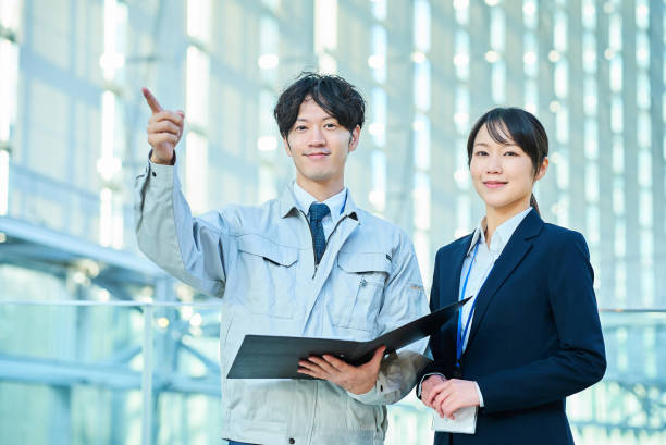 istock A man in work clothes and a woman in a suit 2027865817