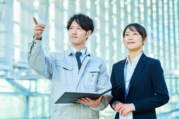 istock A man in work clothes and a woman in a suit 2027867398