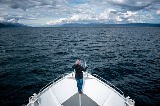 Tourist sailing through the Beagle Channel in Argentine Patagonia. Beautiful view of the Beagle Channel on the border between Argentina and Chile. Person facing the immensity of the Beagle Channel
