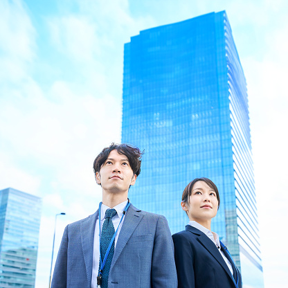 Man and woman in suits standing side by side