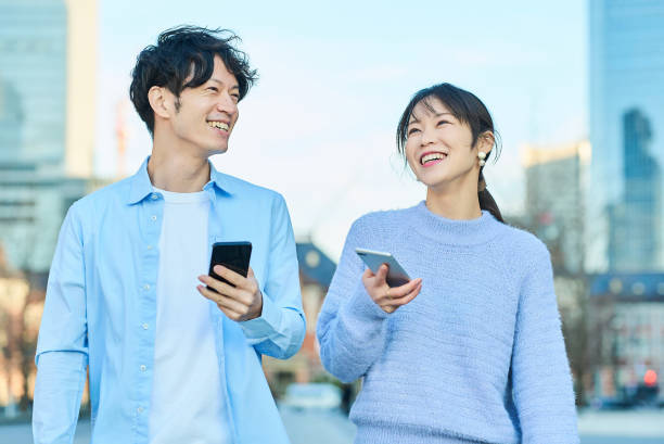 istock Smiling man and woman with smartphone in hand 2027873813