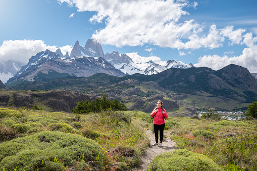 Tourist on the way to the imposing Fitz Roy mountain, Argentina. Happy young woman on the way to Fitz Roy in Argentine Patagonia. Confident mountaineer before climbing Fitz Roy in Argentina