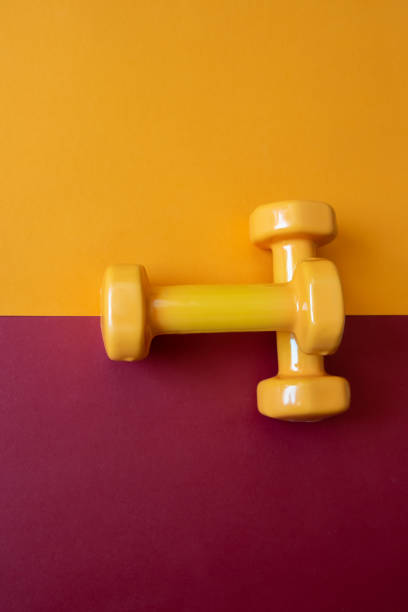 istock Two dumbbells for sport on orange background. 2027902197