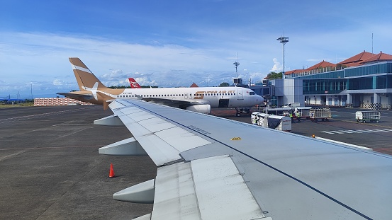Bali, Indonesia - January 21, 2024: The airport atmosphere can be seen from the plane window with a view of the bright blue sky