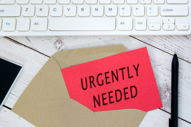 istock Urgently needed text on red card with envelope, white keyboard and pen. 2027926923