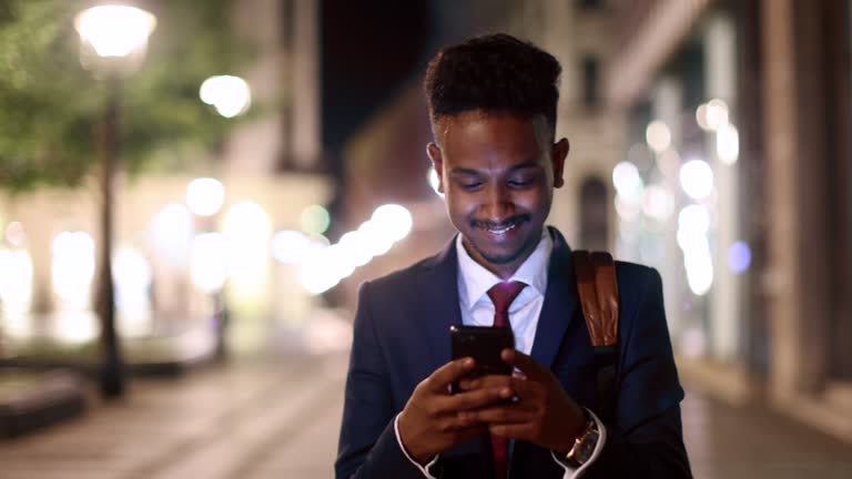 Indian/Pakistani businessman using mobile phone while commuting to/from work