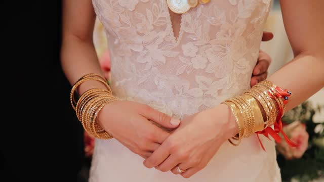 Bride hands and arms with many gold bracelets. Gold gifts from guest presenting. Traditional Turkish wedding jewellery called altin
