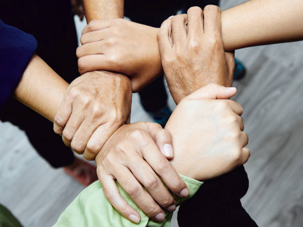 istock A close-up of a diverse team's hands interlocked, symbolizing unity, teamwork, and partnership 2027978006