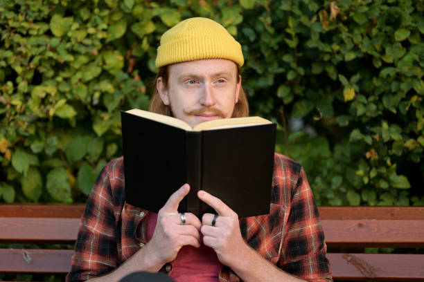 Close up on man reading a bookHe makes a happy facial expression and smiling
