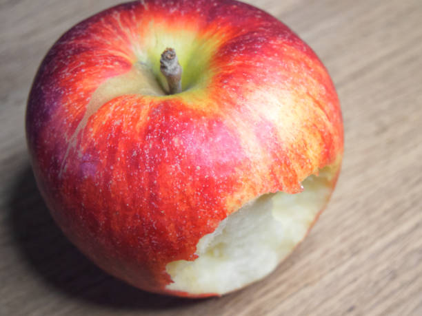 istock Big bitten apple on a wooden background. Ripe red apple. Close-up. 2027992923