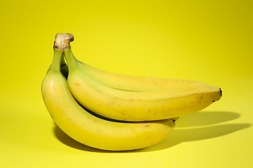 Racimo de plátanos sobre fondo amarillo photo