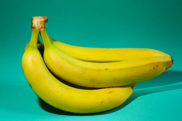 istock Bunch of bananas on the green background 2028012913