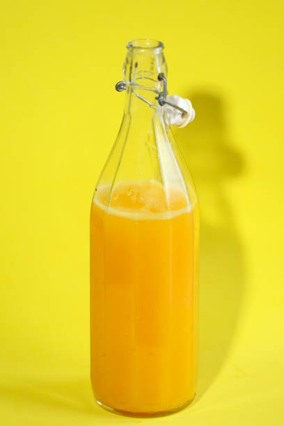 istock Bottle of orange soda with yellow background 2028014552