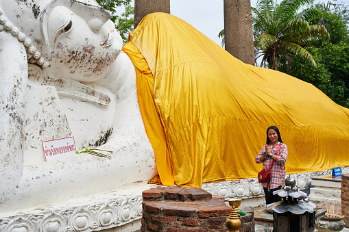 Bangkok, Thailand - August 26, 2023: a thai woman praying at Wihan Phra Mongkhon Bophit temple. Ayutthaya. Phra Nakhon Si Ayutthaya province. Thailand.