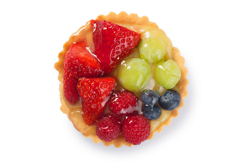Studio shot of an individual fresh fruit flan cut out against a white background