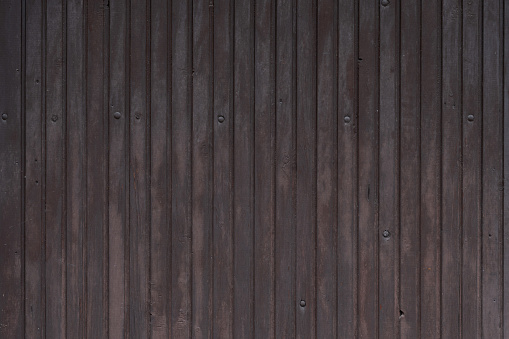 Door made of vertical wooden slats painted in brown