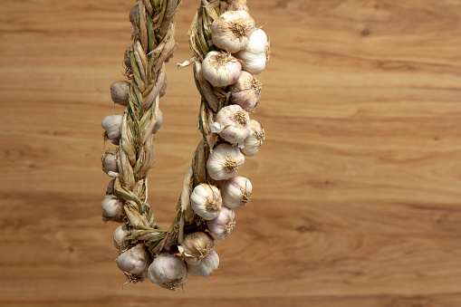 Garlic braid on old wooden background