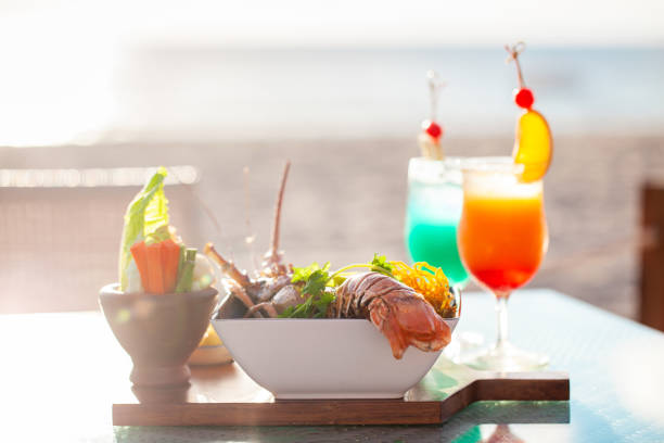 istock Fresh seafood dish and tropical cocktails on beachside table. Summer dining and vacation. 2028072652