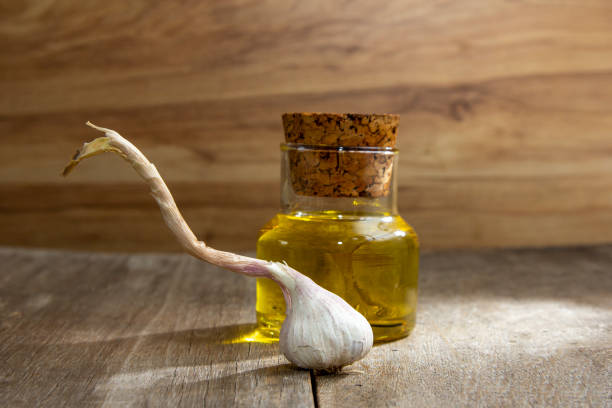 Garlic braid on old wooden background with Olive Oil container