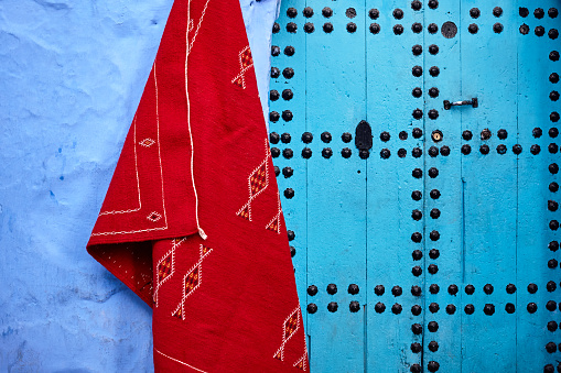 Front view blue door with red carpet in Chefchaouen, Morocco, North Africa.
