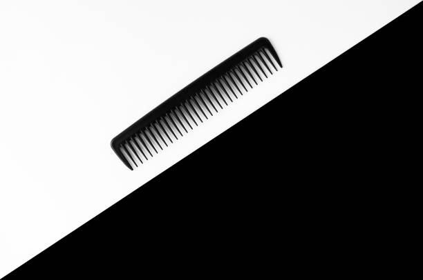 Black comb on the white and black background.Top view. Copy space.
