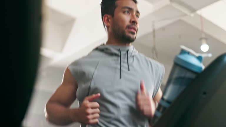 Man, fitness and running on treadmill with smartwatch for timer, workout progress and health check at gym. Young person or runner on cardio or stationary machine for speed exercise or sports training