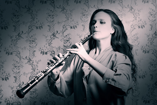 Classical musician oboe playing. Oboist with musical instrument in retro style
