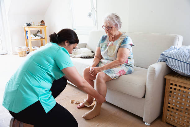 istock senior woman getting help with putting on surgical stockings 2028216974